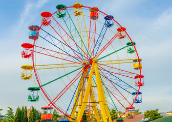 Ferris wheel in the park against the blue sky.