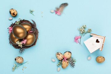 Easter Decoration with golden eggs, quail feathers, dried flowers on blue background. Happy Easter card concept.