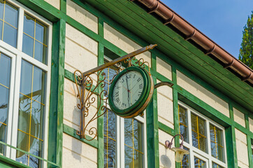 Fototapeta na wymiar Round clock on the wall of a wooden house.