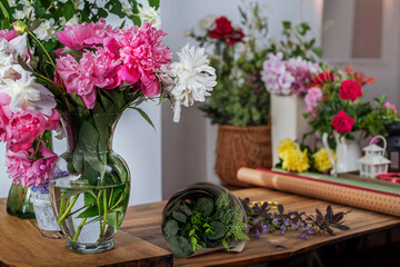 Crop view saller glass vase with blooming peonies. Arrangement of bouquets