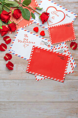 Naklejka na ściany i meble Red roses in bouquets. Letters, mail, craft shopping bag, greetings, valentines, stamps, stars, stripes, circles, hearts, roses, petals, wooden background.