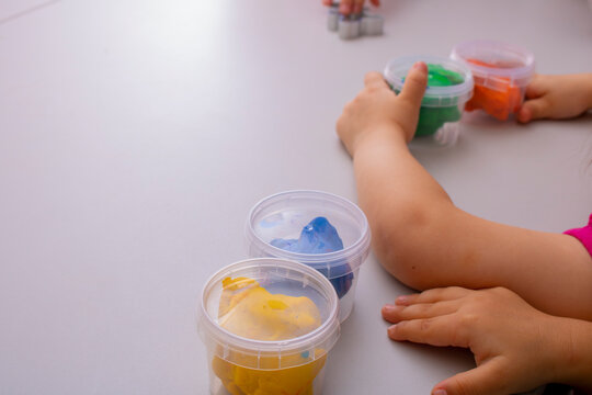 Little girls creating toys from play dough, place for text