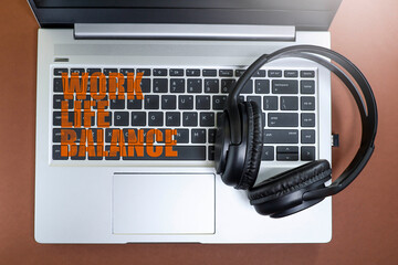 View from above of a message on work-life balance written on the laptop keyboard with a headphone 