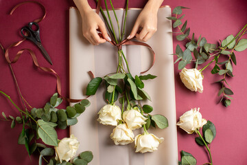 Woman making bouquet from white roses