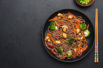 Vegan Stir fry with vegetables and mushrooms  in black bowl. Close up view. Black slate background