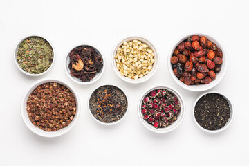 Different types of tea in bowl on white background. Rose hips, jasmine, rose flower, green, berry, hibiscus tea