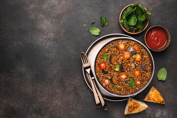 Lentils, eggplants and tomatoes in bowl. Stewed vegetables and legumes for healthy diet. Vegan food