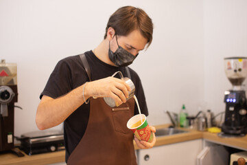 Barista making coffee in coffeeshop.