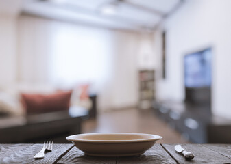 empty plate with fork and knife on wooden table