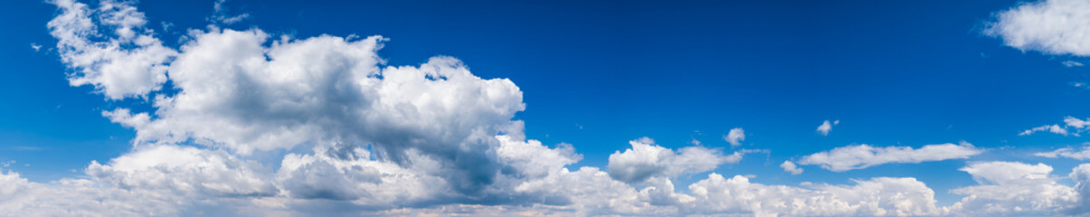 Blue sky with clouds in sunlight, wide cloudscape background panorama