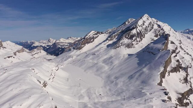 Aerial footage of the Gemmi pass on a sunny winter day above the Leukerbad village that links the Cantons of Valais and Bern in the alps in Switzerland