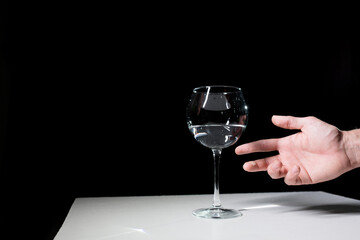 Wine glass and hand on a black background. 