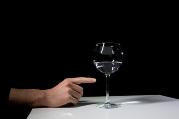 Wine glass and hand on a black background. 