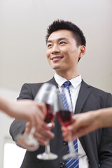 Portrait of businessman holding a glass of wine and toasting