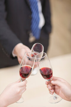 Portrait of businessman holding a glass of wine and toasting,close-up