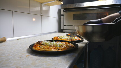 Male arm of cook in glove putting a cabbage mixed in mayonnaise on pita bread using a spoon at cuisine. Chef preparing to serve lavash at restaurant. Concept of cooking food. Dolly shot Slow motion