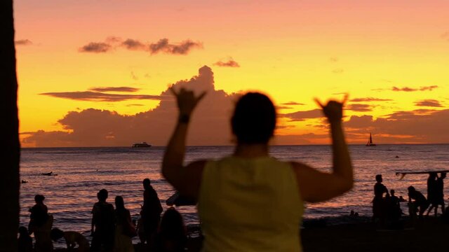 Woman Showing The Shaka hawaii love symbol at sunset in 4K Slow motion 60fps