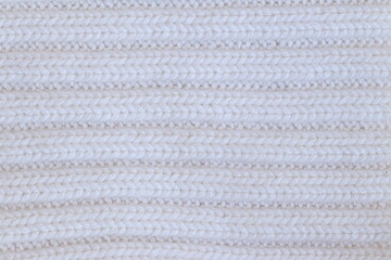 The texture of a light knitted sweater fabric.
