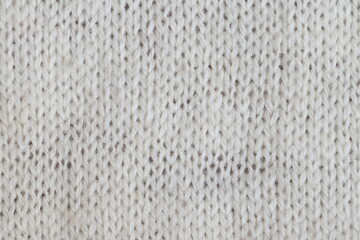 The texture of a light knitted sweater fabric.
