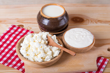 cottage cheese, milk and rustic sour cream on a wooden table