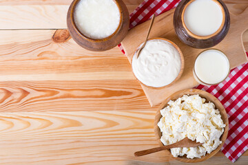 Obraz na płótnie Canvas cottage cheese, milk and rustic sour cream on a wooden table