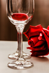 Two glasses with red heart inside and a red rose . Love, romance. Valentine’s day concept.