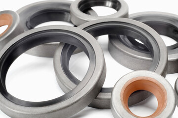 Different rubber reinforced oil seals for shafts and for car motor engines on white background,...