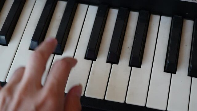 Female Fingers Play Music On The Keys Of An Old, Dirty Synthesizer .