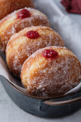 Traditional German Polish Donut with Raspberry Jam Dusted with Sugar. The traditional meal on Fat Thursday, the last day of the carnival.