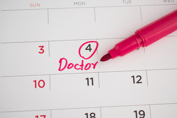 important doctor appointment schedule write on white calendar page date close up