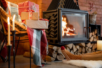 Place by a burning fireplace decorated with a New Year's presents at cozy home interior