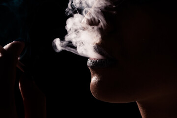 Girl smoke cigarette in the studio. Close up smoker