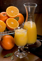 glass of fresh orange juice with fresh fruits on wooden