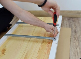 man assembling a new chest of drawers