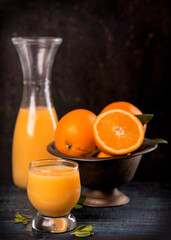 glass of fresh orange juice with fresh fruits on wooden