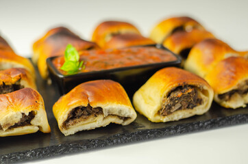 Patty's pies stuffed with minced meat, mushrooms and onion, served with sauce