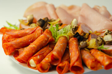 A cold plate prepared for the party with sliced chorizo, ham and sausages
