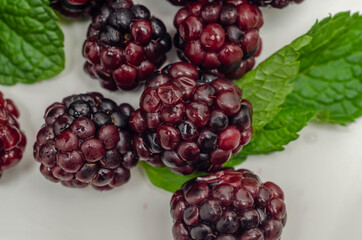 Closeup of a set of blackberries with mint, fresh and ripe forest fruits