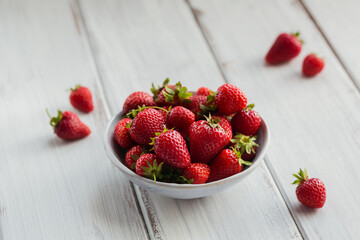 Heap of fresh strawberries in ceramic bowl on white background. Healthy eating and diet food concept.