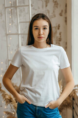 Stylish girl wearing white t-shirt posing in studio