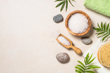 Spa treatment background. Sea salt, towel, palm leaves, at stone table. Flat lay image with copy space.