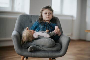 Trauriges Mädchen mit Puppe sitzt in einem Stuhl