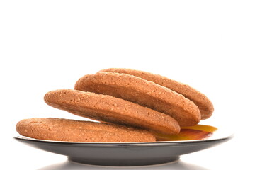 Several freshly baked round American cookies on a ceramic saucer, close-up, isolated on white.