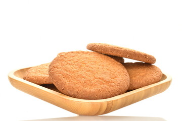 Several freshly baked round American cookies in a bamboo dish, close-up, isolated on white.
