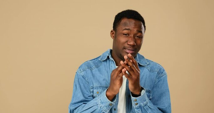Bored african american man clapping hands over beige background