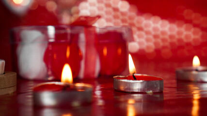 Candles for valentines day, table with festive red background.