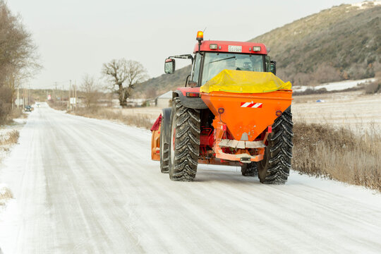 grader cleaning asphalt raod from ice and snow winter transportation problems