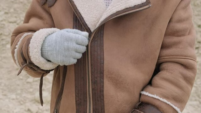 Close up of man zipping his winter jacket at outdoor