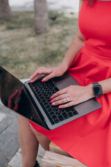 a girl in a red dress holds a laptop in her hands