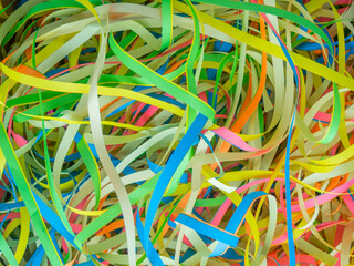 Abstract background close up colorful holiday paper ribbons.Celebration serpentine.Bunch of green,blue,pink,yellow curly mixed tapes,streamers.Concept of congratulation,festive event,fun.Copy space.